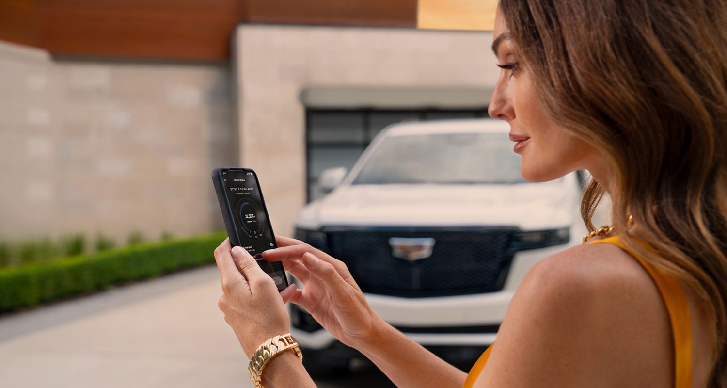 lady checking her mobile with a Cadillac vehicle background | Eric von Schledorn Cadillac in Saukville WI
