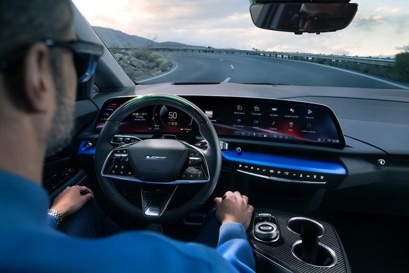 Front View of the 2026 OPTIQ-V Driving Through the Dusk Utilizing its Headlights | Eric von Schledorn Cadillac in Saukville WI